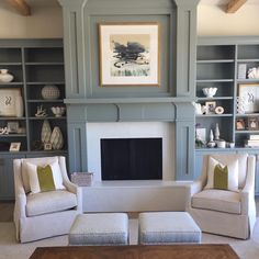 a living room filled with furniture and a fire place in front of a book shelf