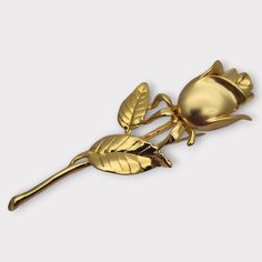 Vintage golden rose shaped brooch, symbolizing glamorous elegance and eye-catching opulence. With a matte gold finish combined with a shiny finish, this brooch adds a touch that will catch everyone's attention. Retro Gifts for Women. *Dimensions: It measures 10 cm long and 3.5 cm wide, approximately. *Weight: It weighs 34.24 grams. **Composition Main material: Gold metal. Contrast: Not visible. Acid test: Performed. Other materials: Metal **Additional details: It is not new and has signs of use, Formal Gold Brooch With Rose Design, Golden Floral Design, Jewelry 90s, Art Nouveau Yellow Gold Brooches Gift, Gold Flower-shaped Brooches For Gifts, Antique Gold Flower Brooch, Victorian Gold Flower Brooches, Vintage Gold Flower Shaped Brooch, Golden Rose