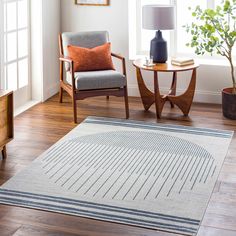 a living room filled with furniture and a rug on top of a hard wood floor