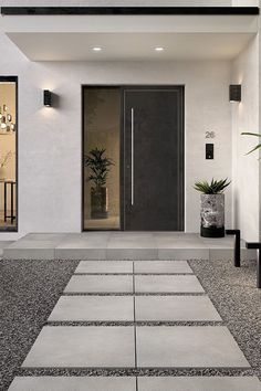 the entrance to a modern house with black and white accents