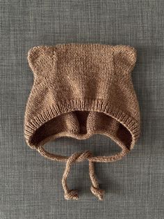 a knitted bear hat on top of a gray surface