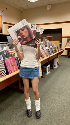 a woman holding up a magazine in front of her face