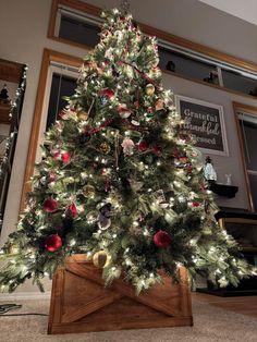 a christmas tree with ornaments on it in a living room