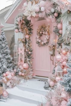 a pink door decorated with ornaments and wreaths