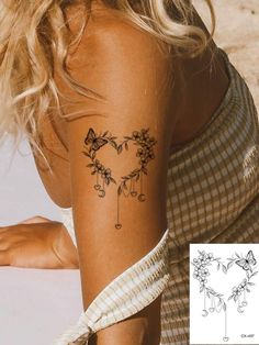 a woman with a tattoo on her arm that has flowers in the shape of a heart