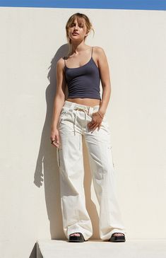 Step out in style with the Bone Low Rise Baggy Flare Pants from PacSun. Designed for both comfort and utility, these pants feature a low-rise fit, ribbed drawstring waistband, and zipper side pockets. Complete with cargo strap pockets on the legs and flared leg openings, they offer a trendy, relaxed baggy look for any occasion. Summer Cotton Mid-rise Parachute Pants, Summer Mid-rise Cargo Parachute Pants, Cream Wide Leg Cargo Pants, White Mid-rise Summer Cargo Pants, Cream Wide Leg Cargo Pants For Summer, White Cargo Style Parachute Pants For Summer, Wide-leg Cream Cargo Pants For Summer, Casual Cream Cargo Pants For Summer, Boujee Style