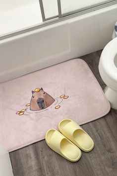 a pair of slippers sitting on top of a bathroom floor next to a toilet