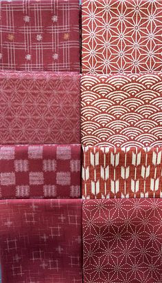 red and white fabrics are stacked on top of each other in different sizes, patterns and colors