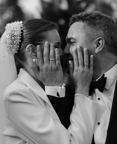 the bride and groom are holding their hands to their faces as they look into each others eyes