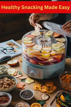 a food processor with apples, oranges and nuts in it on top of a table