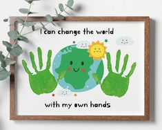 a wooden frame with green handprints on it and the words, i can change the world with my own hands