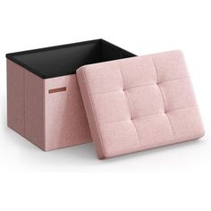 a pink and black storage box sitting on top of a white floor next to an ottoman