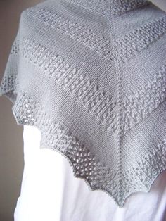 a white knitted shawl on top of a mannequin