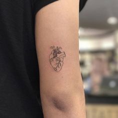 a small heart tattoo on the arm