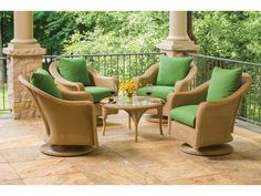 an outdoor patio with wicker furniture and green cushions