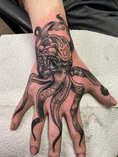 an octopus tattoo on the left hand