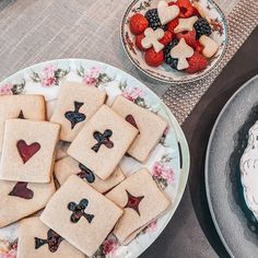 some cookies are sitting on plates next to a cake