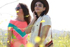 two women standing next to each other in a field