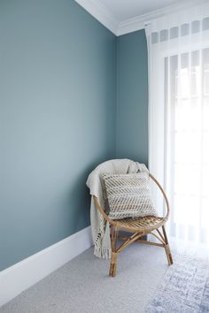 a chair sitting in the corner of a room with a blanket on top of it