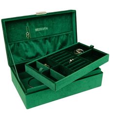 two green velvet jewelry boxes with rings in them, one opened and the other closed