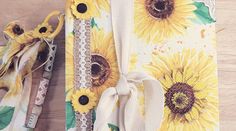 two sunflowers are on the table next to each other with ribbons tied around them