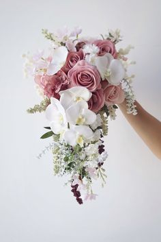 a bouquet of flowers is being held by someone's hand on a white background