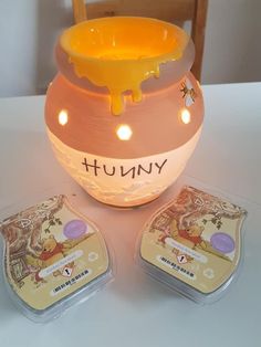 a yellow and pink vase sitting on top of a table next to two coasters