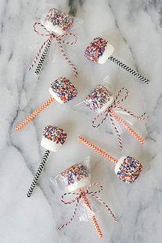 candy lollipops wrapped in clear cellophane and decorated with colorful sprinkles