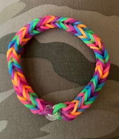 a multicolored bracelet is displayed on a camo background