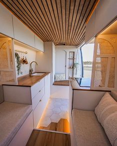 the interior of a tiny house with white walls and wood ceilinging is lit by recessed lights