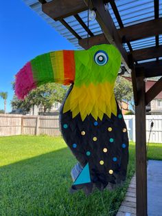 a colorful toucan hanging from a pergolated roof