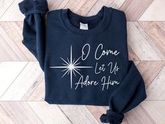 "Embrace the spirit of the season with our enchanting \"Oh Come Let Us Adore Him\" Christmas Sweatshirt - a soulful addition to your festive wardrobe. This Christian-themed sweatshirt goes beyond mere fashion, capturing the essence of the holiday with a powerful message. Perfect for those who seek a meaningful touch in their attire, this Christmas Sweater is a beacon of Christian Christmas cheer, radiating warmth and joy. Crafted for comfort and style, our Religious Christmas sweatshirt allows you to wear your faith with pride, making it the ideal Christian Sweatshirt for spreading love and adoration during the holiday season. Let the timeless words \"Oh Come Let Us Adore Him\" grace your holiday celebrations, whether you're attending a Christmas service or gathering with loved ones. This Christian Christmas Shirts, Church Christmas Decorations, Come Let Us Adore Him, Christmas Service, True Meaning Of Christmas, Christian Sweatshirt, Religious Christmas, Xmas Shirts, Christian Christmas