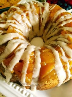 a bundt cake with white icing and fruit on the side