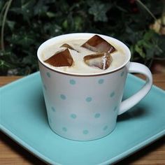 a cup filled with liquid and ice on top of a blue plate