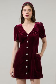 Looking for an elegant mini dress? This velvet mini is the perfect mix between the ideal holiday and fall dress. Features a gathered shoulder on a short sleeve that frames a shapely silhouette and has gorgeous silvers button’s all the way down. Princess seams pave the way along the front panels, lying parallel to a hidden zipper closure.- Velvet- Button up mini dress- Princess seams- Pockets- Comes in 3 colorsSize + Fit - Model is 5'8" and wearing size XS- Measurements taken from size S - Chest: V-neck Buttoned Mini Dress For Cocktail, Formal Mini Dress With Puff Sleeves And Buttons, Formal Puff Sleeve Mini Dress With Buttons, Puff Sleeve Mini Dress With Buttons For Party, Fitted Puff Sleeve Mini Dress With Buttons, Cocktail Mini Dress With Button Closure, Evening Mini Dress With Button Closure, Mini Dress With Button Closure For Evening, Short Sleeve Mini Dress With Buttons For Evening