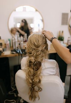 a woman sitting in a chair getting her hair done