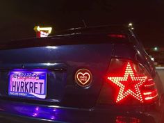 a blue car with a heart shaped star on it's tail light and license plate