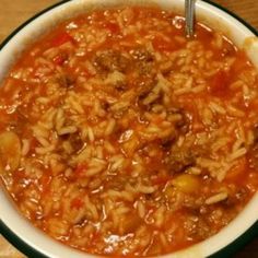 a bowl filled with pasta and meat on top of a wooden table