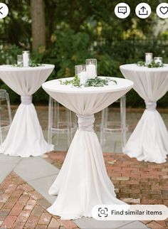 the tables are set up with white linens and greenery on them for an outdoor wedding