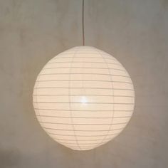 a large white paper lantern hanging from a ceiling