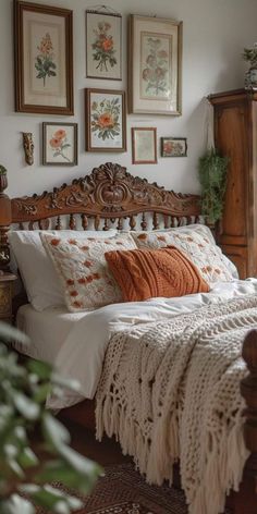 a bed sitting in a bedroom next to a window with pictures on the wall above it