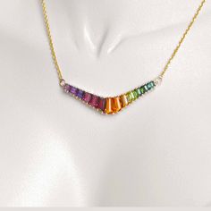 Discover our 18K Gold Rainbow V-Shaped Pendant Necklace, a striking fusion of vibrant hues and contemporary design that embodies diversity and self-expression. This pendant showcases a sleek V shape adorned with meticulously arranged multicolored gemstones, forming a captivating spectrum symbolizing unity within differences. V Pendant, Fashion Jewelry Necklaces Gold, Necklaces Gold, Rainbow Necklace, Gold Fashion Necklace, Fashion Board, Fashion Jewelry Necklaces, Gold Fashion, V Shape