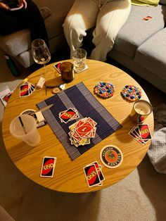 a wooden table topped with lots of stickers on top of a floor next to a couch