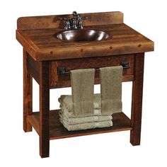 a wooden sink with two towels and a faucet on the stand next to it