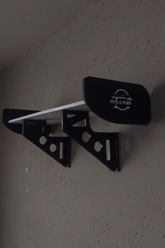 two pieces of black plastic hang on the wall