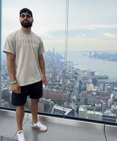 a man standing in front of a window overlooking the city