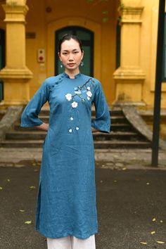 Spring Embroidered Cheongsam With Stand Collar, Fitted Ao Dai With Floral Embroidery And Stand Collar, Fitted Embroidered Ao Dai With Stand Collar, Embroidered Fitted Ao Dai With Stand Collar, Traditional Spring Kurta With Embroidered Hem, Spring Floral Embroidered Ao Dai, Spring Floral Embroidery Ao Dai, Traditional Long Kurta For Spring, Traditional Embroidered Blue Ao Dai