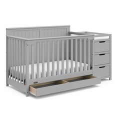 a gray crib with drawers underneath it