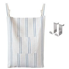 a white and blue striped bag next to two hooks