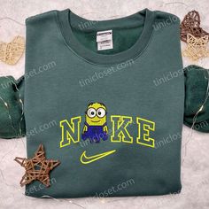 Minion x Nike Embroidered Shirt, Cartoon Embroidered Hoodie, Nike Inspired Embroidered Sweatshirt Welcome to Tinicloset, your one-stop destination for the most adorable and iconic custom embroidered shirts and apparel that will surely tickle your fancy and make you fall in love with fashion all over again. Our store is a treasure trove of creativity, where we blend the whimsy of Minions and the style of Nike to bring you a unique fusion of cuteness and iconic fashion. At Tinicloset, we believe t Green Casual Hoodie With Custom Embroidery, Casual Green Hoodie With Custom Embroidery, Streetwear Embroidered Fleece Sweatshirt, College Embroidered Hoodie Tops, Sporty Embroidered Fleece Sweatshirt, Casual Embroidered Hoodie For College, Casual College Hoodie With Custom Embroidery, Green Crew Neck Hoodie With Embroidered Graphics, Green Sporty Sweatshirt With Embroidered Graphics